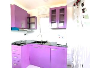 a kitchen with purple cabinets and a sink at The Mulberry Villa kandy in Kandy