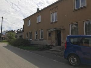 a blue van parked in front of a house at Wohnung Regina in Wildenfels
