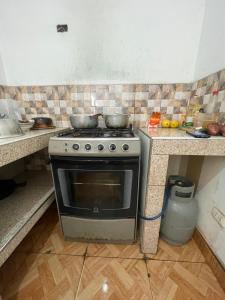 a kitchen with a stove with two pans on it at Hospedaje vista del sur paracas in Paracas