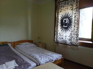a bedroom with two twin beds and a window at Nimród vendégház in Mőcsény