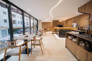 a dining room with a table and chairs and windows at Hotel Digreis in Vlorë