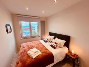 a bedroom with a large bed with a window at Cosy Of John Cockerill in Seraing