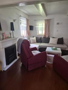 a living room with a couch and a chair at Roubenka Krkonoše - Adršpach in Radvanice