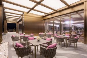 a restaurant with tables and chairs with pink pillows at Mercure Beijing Lize Road in Beijing