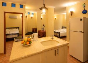 a kitchen with a sink and a bowl of fruit on the counter at נופש דביר - צימרים מהממים למשפחות עם ג'קוזי ובריכה ליד הכנרת in Migdal