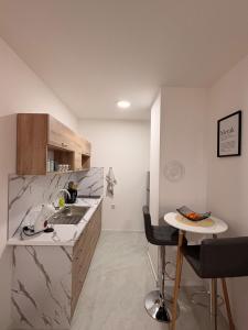 eine Küche mit Spüle und kleinem Tisch in der Unterkunft Apartment EDA in Bosanska Krupa