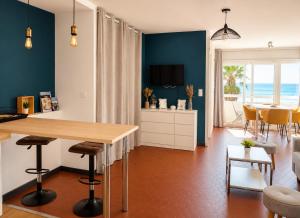 a kitchen with a table and a dining room with the ocean at ROSEVA - T2 Vue mer - Plage à pied - Balcon - Climatisation in Canet-en-Roussillon