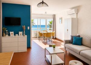 a living room with a couch and a table at ROSEVA - T2 Vue mer - Plage à pied - Balcon - Climatisation in Canet-en-Roussillon