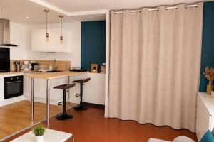 a kitchen with a table and chairs and a curtain at ROSEVA - T2 Vue mer - Plage à pied - Balcon - Climatisation in Canet-en-Roussillon +6 photos