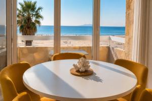 a table with a hat on it in a room with a beach at ROSEVA - T2 Vue mer - Plage à pied - Balcon - Climatisation in Canet-en-Roussillon