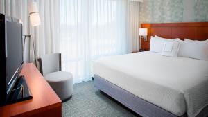 a hotel room with a bed and a television at Courtyard by Marriott Ann Arbor in Ann Arbor