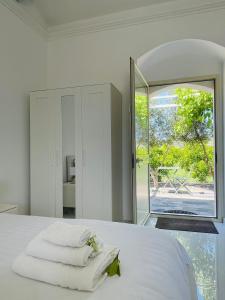 a bedroom with a bed with white sheets and a mirror at Zagara Suite in Francofonte