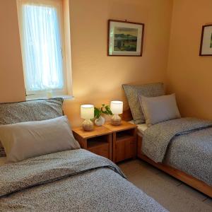 a bedroom with two beds and a table with two lamps at Margaréta Apartman in Balatonudvari +11 photos