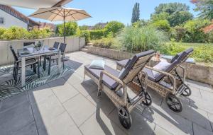 a patio with two chairs and a table with an umbrella at Fewo Strandliebe in Gaienhofen
