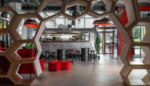 a restaurant with red stools and a bar at Radisson RED Dubai Silicon Oasis in Dubai