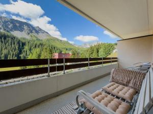 a chair on a balcony with a view of a mountain at Irmella 39 by Arosa Vacations, mit Pool & Sauna in Arosa