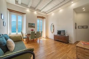 a living room with a couch and a table at Emy House Charming Apt Stunning Views Balcony AC in Carate Urio