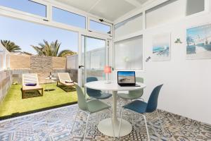 a dining room with a table and chairs with a laptop on it at CarpeDiem Costa de Antigua in Costa de Antigua