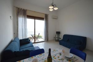 リーヴァ・リーグレにあるRiva Mare Apartmentのリビングルーム(青いソファ2台、テーブル付)