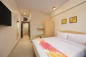 a bedroom with a bed and a flat screen tv at Ginger Pantnagar in Pantnagar