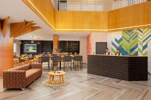a lobby with a bar with chairs and tables at Ginger Pantnagar in Pantnagar