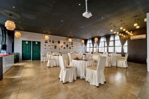 a banquet hall with white tables and white chairs at Treebo ESS Grande in Coimbatore