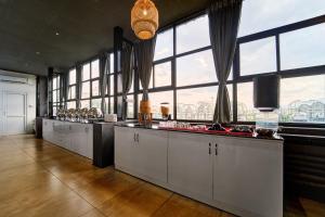 a large kitchen with white cabinets and large windows at Treebo ESS Grande in Coimbatore