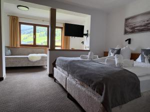a hotel room with two beds and a couch at Haus Traudl in Filzmoos