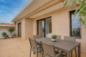 a patio with a wooden table and chairs at Dolce Vita in Fréjus