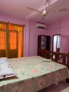 a bedroom with a large bed with pink walls at Nuwanma in Halpatota