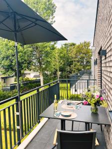 a patio with a table and an umbrella at Küste33 34 in Tossens