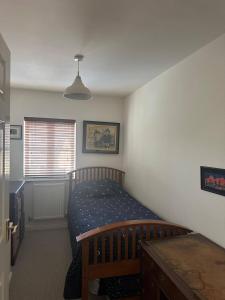 a small bedroom with a bed and a window at Super comfy, convenient two bedroom apartment in Corsham