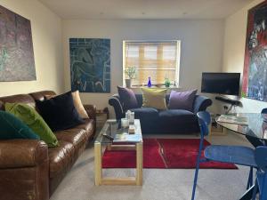 a living room with a couch and a table at Super comfy, convenient two bedroom apartment in Corsham