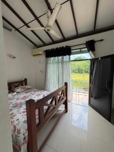 a bedroom with a bed and a large window at Nuwanma in Halpatota
