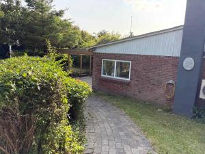 a brick house with a brick walkway next to a building at Cozy Summerhouse in Vestervig