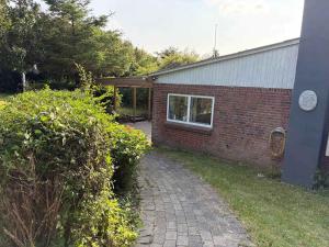a brick house with a brick walkway next to a building at Cozy Summerhouse in Vestervig +19 photos