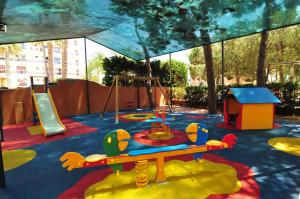 a childrens play area with a swing set and a slide at HomeHolidaysRentals Aqua in Santa Susanna