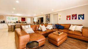 a large living room with a brown leather couch at Ark de Triomphe in Riebeek-Wes