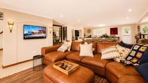 a living room with a brown leather couch at Ark de Triomphe in Riebeek-Wes