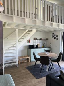 a living room with a table and a staircase at B&B de Landstreek in Hulten