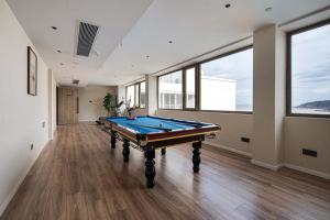 a pool table in a large room with windows at XIHUI Cliff Hotel in Tian'ao