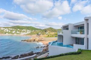 a white house with a view of a beach at XIHUI Cliff Hotel in Tian'ao