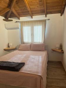a bedroom with a large bed with a window at Apartment Antigoni in Nea Kallikrateia