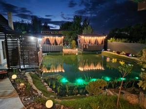 a pool with lights in a backyard at night at Дача рибача in Svityazʼ