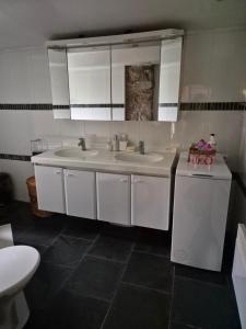 a bathroom with two sinks and two mirrors at Roubenka Krkonoše - Adršpach in Radvanice +12 photos