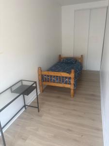 a small bedroom with a bed and a glass table at Belle appartement in Saint-Mihiel
