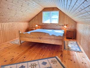 a bedroom with a bed in a log cabin at Stuga Gösjön in Berga