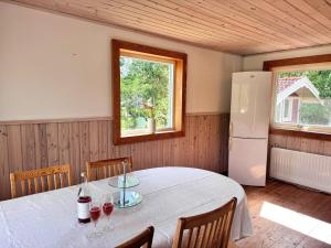 a dining room with a table and a refrigerator at Stuga Gösjön in Berga
