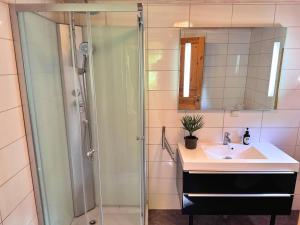 a bathroom with a shower and a sink and a mirror at Stuga Gösjön in Berga +13 photos