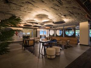 a lobby with a table and some chairs and a ceiling at Sercotel Playa Canteras in Las Palmas de Gran Canaria